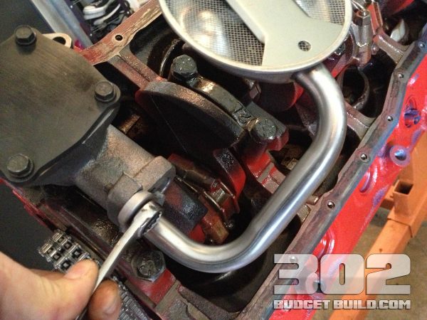 Tighten oil pump screen to oil pump with a 1/2 wrench