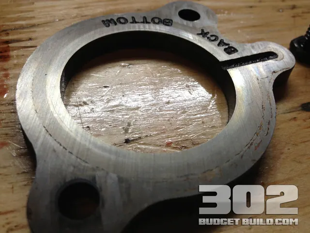 Camshaft backing plate used to hold the camshaft in place on a small block ford 302 5.0 engine. Notice it is engraved back / bottom