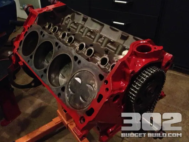 The bare 302 block freshly painted fire engine red on the engine stand